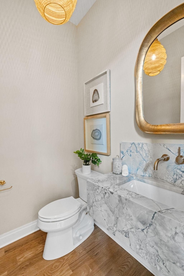 bathroom with sink, hardwood / wood-style floors, and toilet