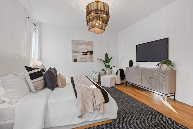 bedroom with wood-type flooring and a chandelier