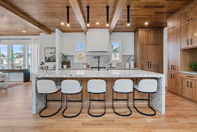 kitchen with a spacious island, light hardwood / wood-style flooring, tasteful backsplash, and wooden ceiling