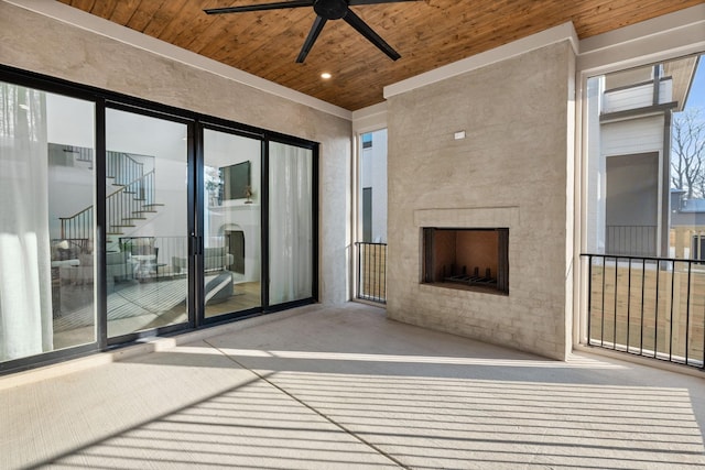 view of patio / terrace with ceiling fan and a large fireplace