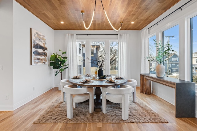 dining area with light hardwood / wood-style flooring and wooden ceiling