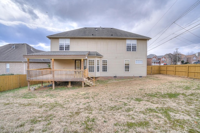 rear view of property featuring a yard and a deck