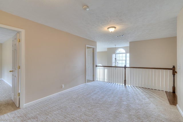 carpeted spare room featuring a textured ceiling