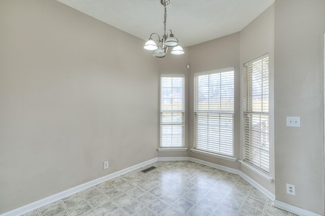 spare room featuring a notable chandelier