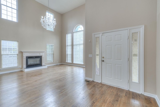 entrance foyer featuring light wood-type flooring, a wealth of natural light, and a high ceiling