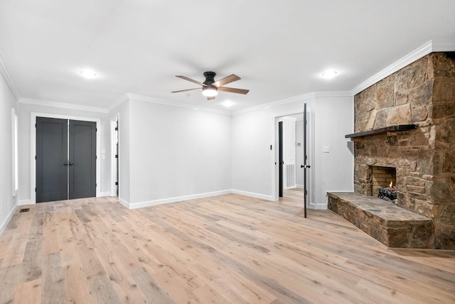 unfurnished living room featuring ornamental molding, ceiling fan, a fireplace, and light wood-type flooring