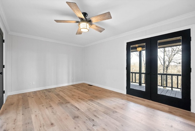 spare room featuring crown molding, light wood-type flooring, and french doors