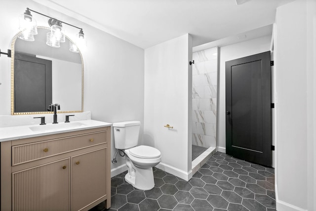 bathroom featuring vanity, tiled shower, and toilet
