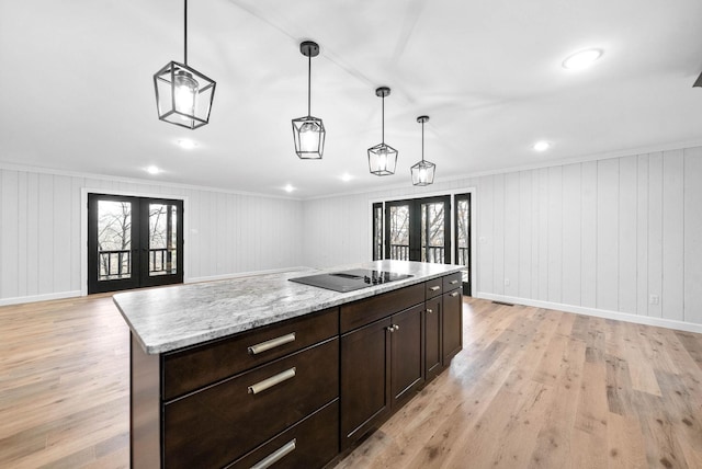 kitchen with black electric cooktop, pendant lighting, french doors, and a center island