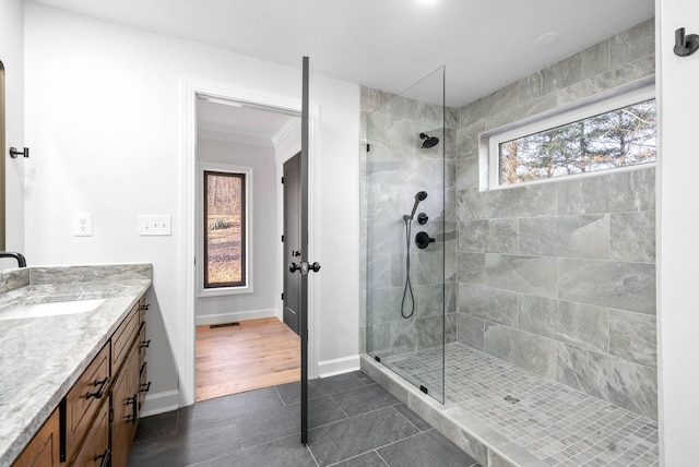 bathroom with vanity, tile patterned flooring, and a tile shower