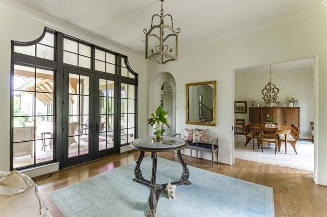 entryway featuring hardwood / wood-style flooring, a chandelier, a wealth of natural light, and french doors