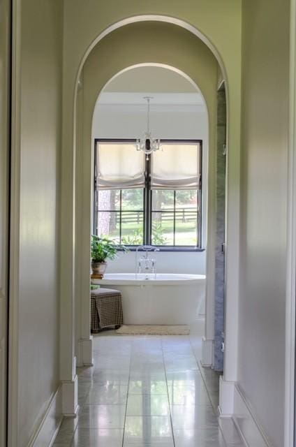 bathroom with a tub, tile patterned floors, and crown molding