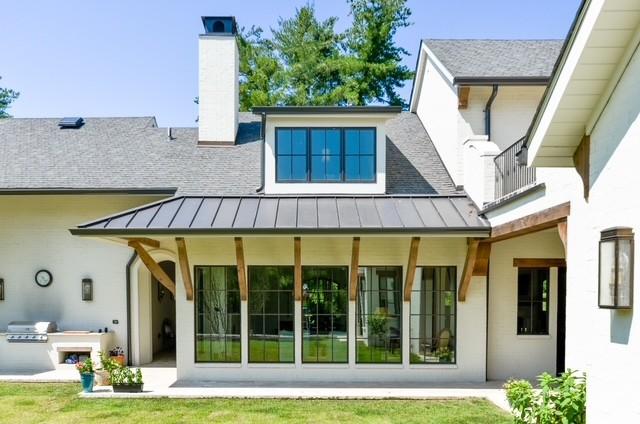 rear view of property featuring an outdoor kitchen and a yard