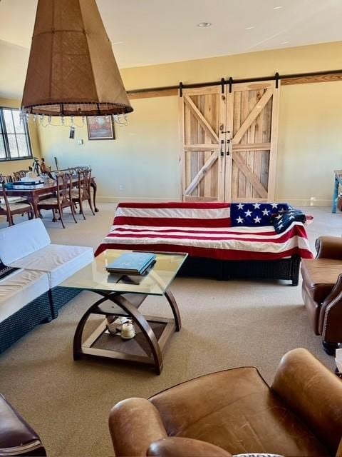 living room featuring a barn door and carpet flooring