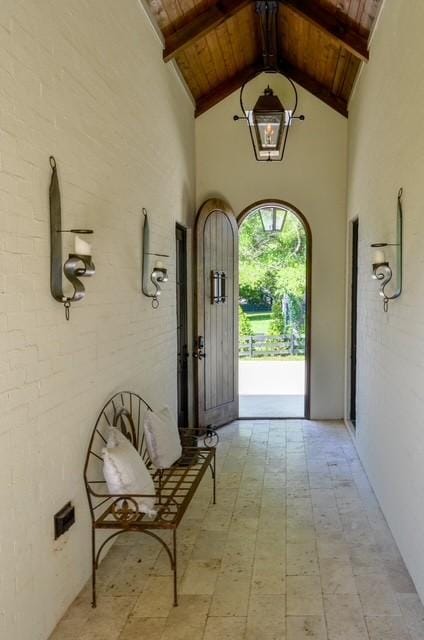 entryway featuring high vaulted ceiling, wooden ceiling, and beamed ceiling