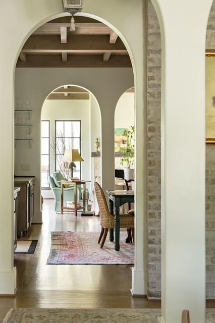 dining area featuring beam ceiling and dark hardwood / wood-style flooring