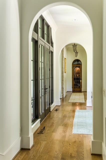 hallway featuring light wood-type flooring and ornamental molding