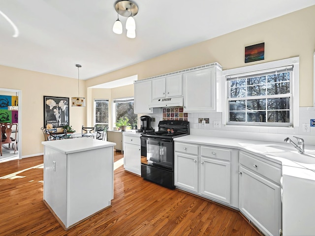 kitchen with black electric range oven, decorative backsplash, hanging light fixtures, and white cabinets