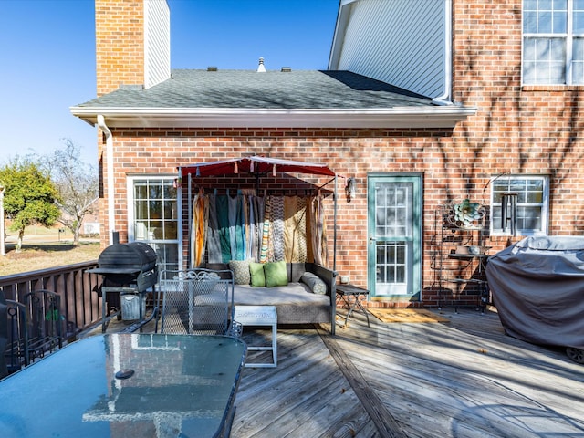 wooden terrace featuring an outdoor living space and area for grilling