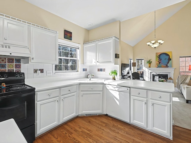 kitchen featuring pendant lighting, white cabinetry, white dishwasher, black electric range, and ventilation hood