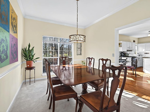 dining space featuring crown molding and light colored carpet