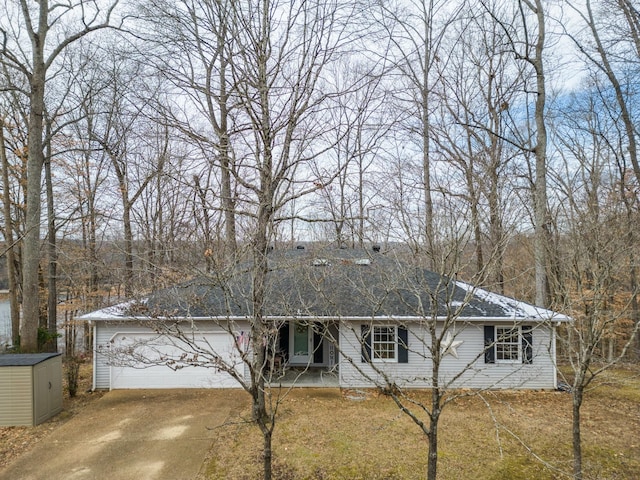 ranch-style house with a storage shed, an outdoor structure, a garage, and driveway