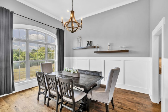 dining area with crown molding, hardwood / wood-style flooring, and a chandelier