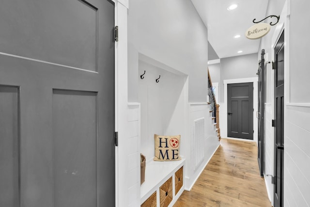 mudroom featuring a barn door and light wood-type flooring