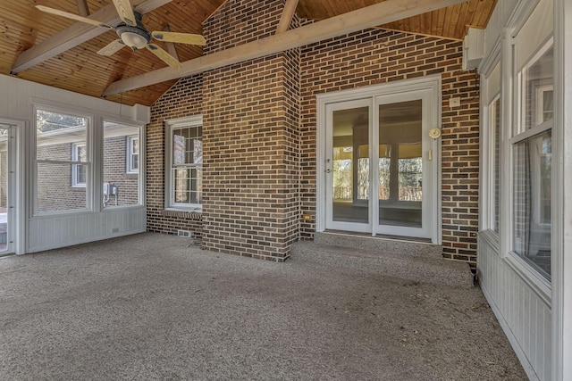 unfurnished sunroom featuring lofted ceiling with beams, wooden ceiling, and ceiling fan