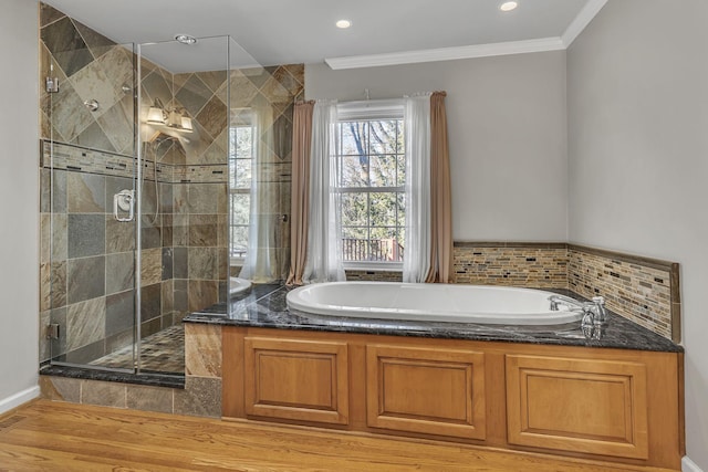 bathroom featuring hardwood / wood-style flooring, ornamental molding, and plus walk in shower