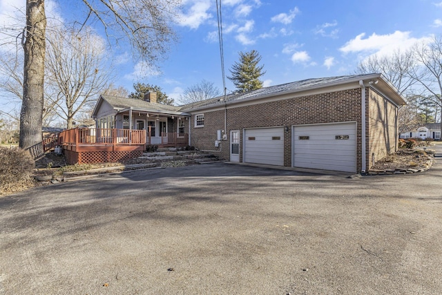 view of front of property with a wooden deck, a garage, and a porch