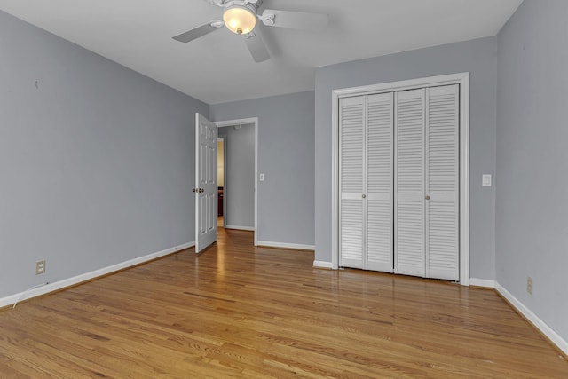 unfurnished bedroom featuring ceiling fan, light hardwood / wood-style floors, and a closet