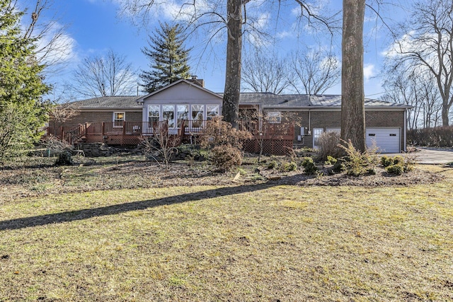 view of front of property with a garage, a front yard, and a deck