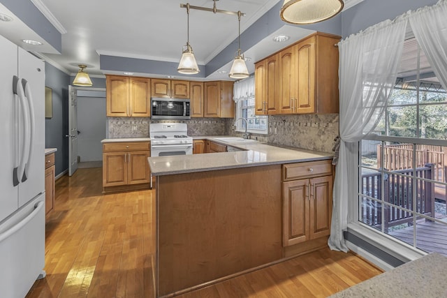 kitchen featuring white appliances, light hardwood / wood-style floors, sink, and backsplash