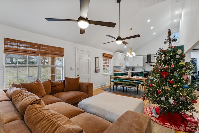 living room featuring ceiling fan, high vaulted ceiling, and light wood-type flooring