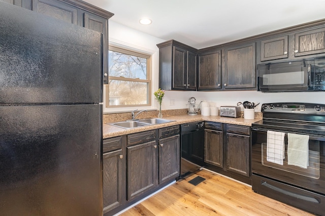 kitchen with light hardwood / wood-style floors, sink, dark brown cabinets, and black appliances