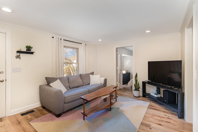 living room featuring ornamental molding and light hardwood / wood-style flooring