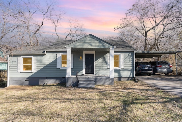 view of front of home featuring a lawn and a carport