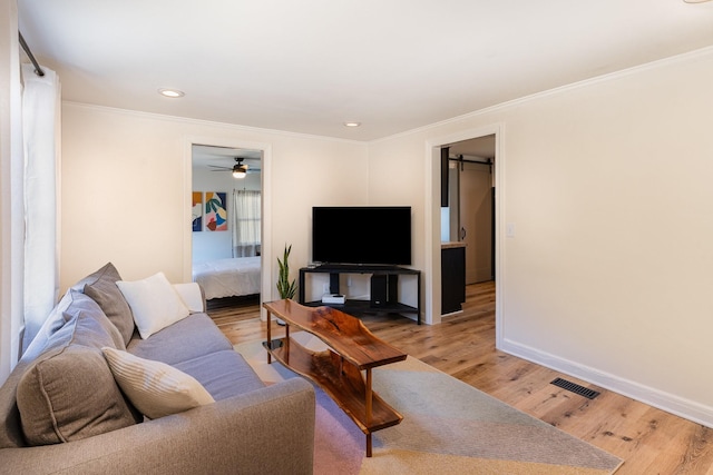 living room with ornamental molding and light wood-type flooring