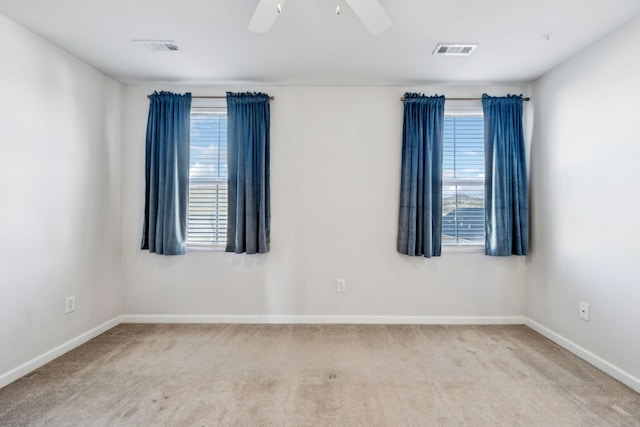 carpeted spare room featuring ceiling fan