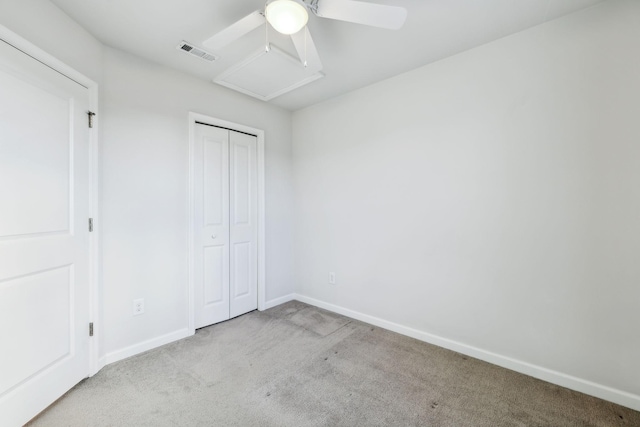 unfurnished bedroom with light colored carpet, ceiling fan, and a closet