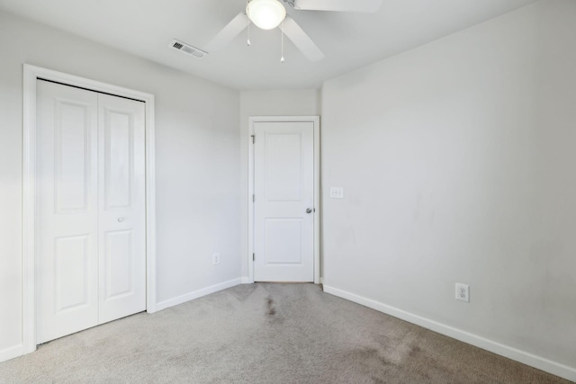 unfurnished bedroom with light colored carpet, a closet, and ceiling fan