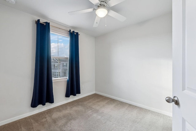 unfurnished room with light colored carpet and ceiling fan