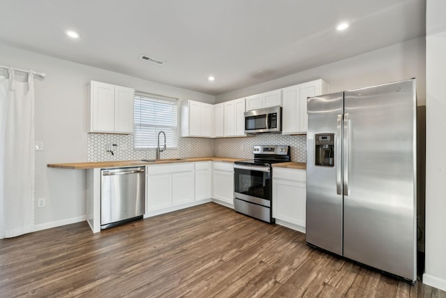 kitchen with sink, wooden counters, appliances with stainless steel finishes, dark hardwood / wood-style floors, and white cabinets