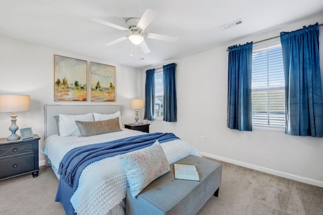 bedroom with multiple windows, light colored carpet, and ceiling fan