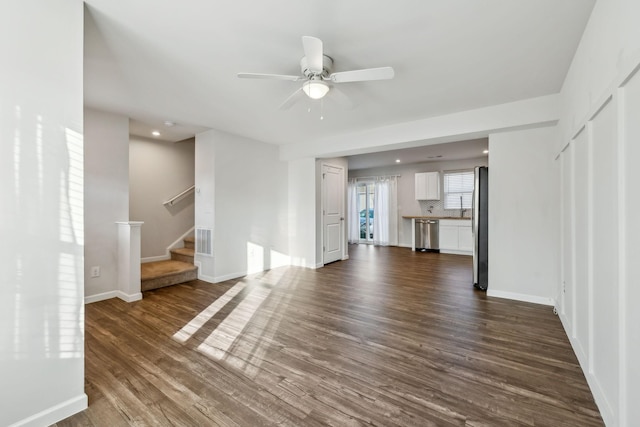 unfurnished living room featuring ceiling fan and dark hardwood / wood-style floors