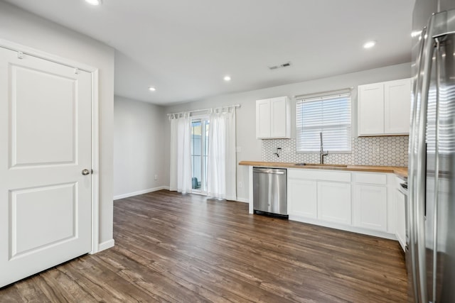 kitchen featuring sink, stainless steel appliances, dark hardwood / wood-style floors, tasteful backsplash, and white cabinets