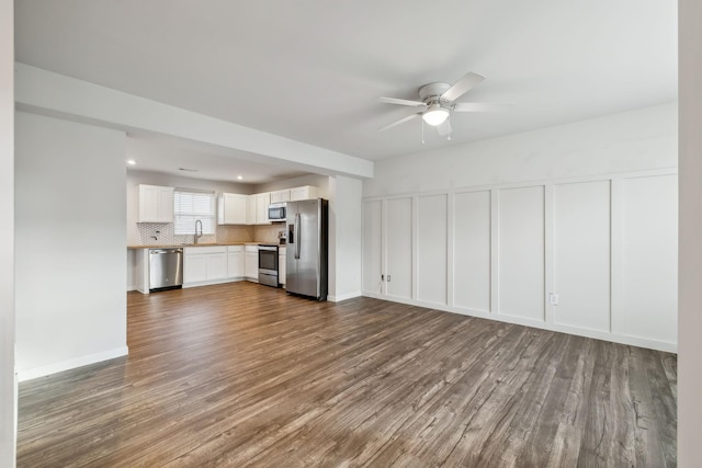 unfurnished living room featuring ceiling fan, dark hardwood / wood-style flooring, and sink