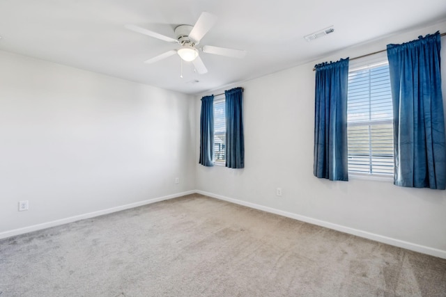 spare room with carpet flooring, a wealth of natural light, and ceiling fan