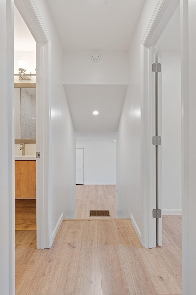 hallway featuring sink and light wood-type flooring